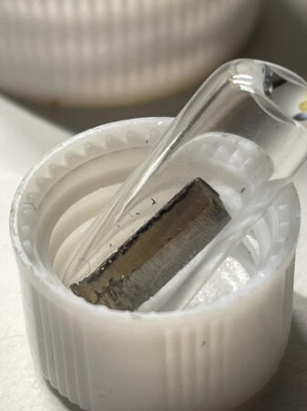 1g of pure Depleted Uranium. Sealed in an ampule to prevent oxidation.